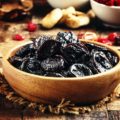 Dried sweet prunes or dark plums in bowl