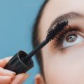 Woman applying mascara on her lashes